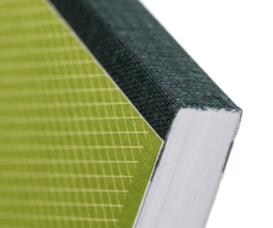 Close-up of a notebook with green grid pattern and dark green binding.