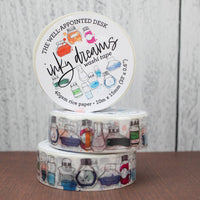 Three rolls of washi tape with decorative labels on a wooden surface.
