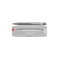 A silver metallic pen with a textured glittery grip, shown above its silver presentation box. The box features the brand name 'CARAN D'ACHE' and a small Swiss flag logo on the left.