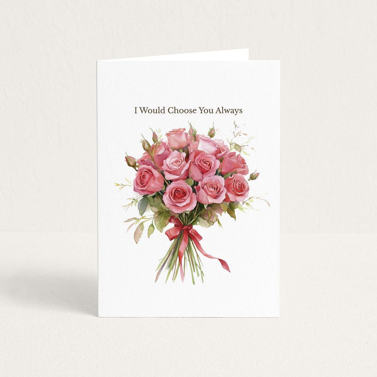 A white greeting card standing upright against a light beige background. The card features the printed phrase 'I Would Choose You Always' above a watercolor-style bouquet of pink roses with green leaves and a red ribbon.