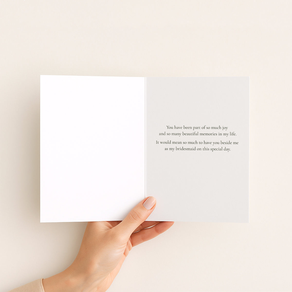 Hand holding a white card with text on a beige background
