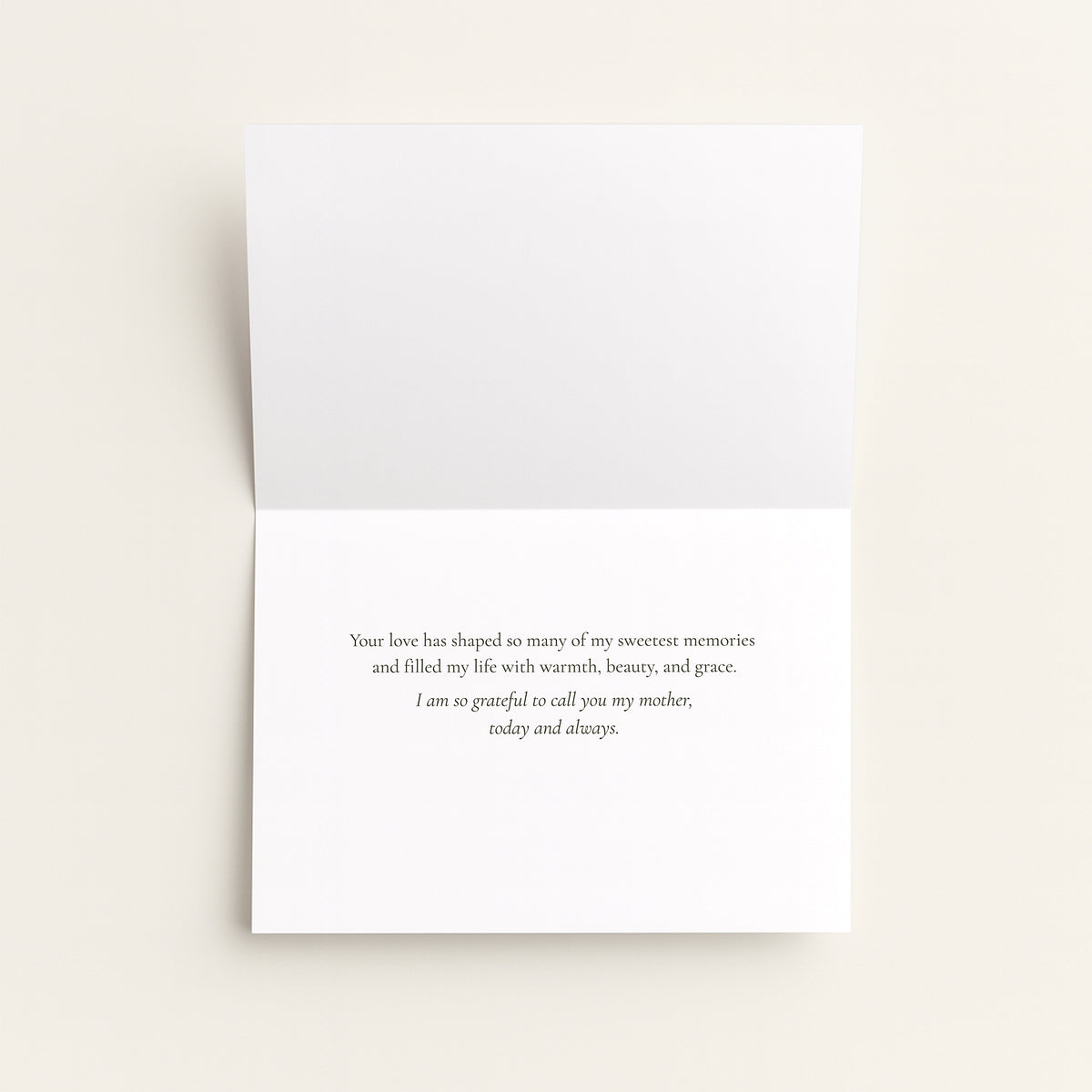 A folded white greeting card with a printed remembrance message in black serif text, photographed against a warm off-white background.