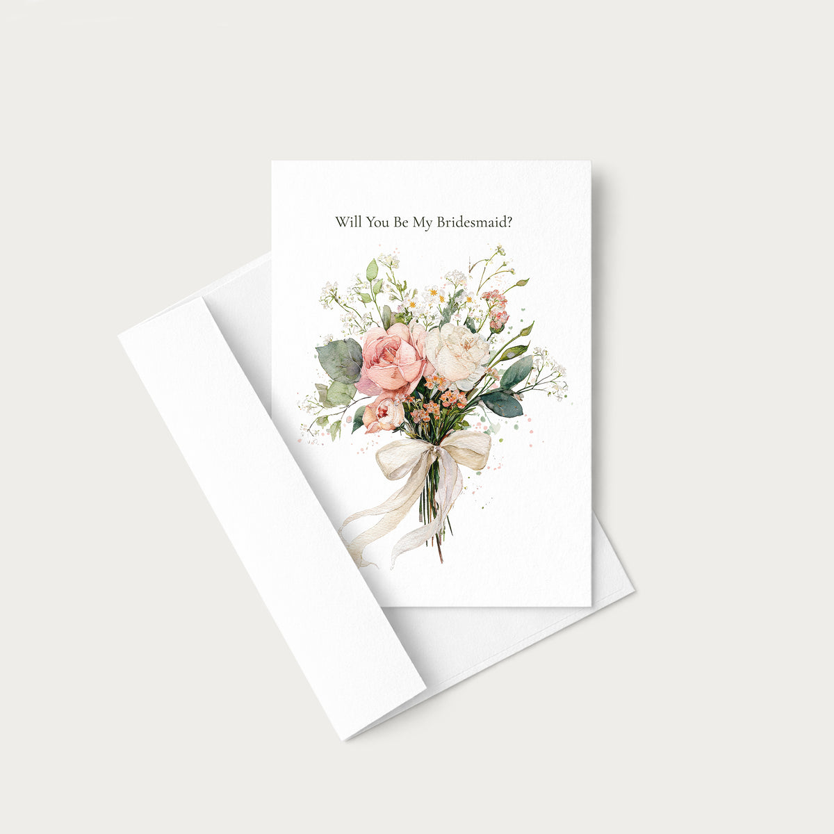 A white greeting card with the text 'Will You Be My Bridesmaid?' above a watercolor bouquet of blush pink, peach, and cream flowers with green leaves, shown with a white envelope on a light warm gray background.