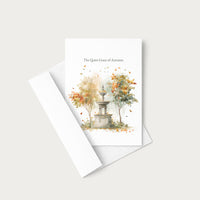 A white greeting card with a watercolor illustration of a stone fountain and autumn trees, with the text 'The Quiet Grace of Autumn' at the top. The card is shown with a white envelope on a light gray background.