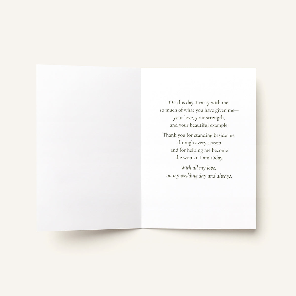 An open white greeting card with a printed message on the right panel, photographed against a warm off-white background.
