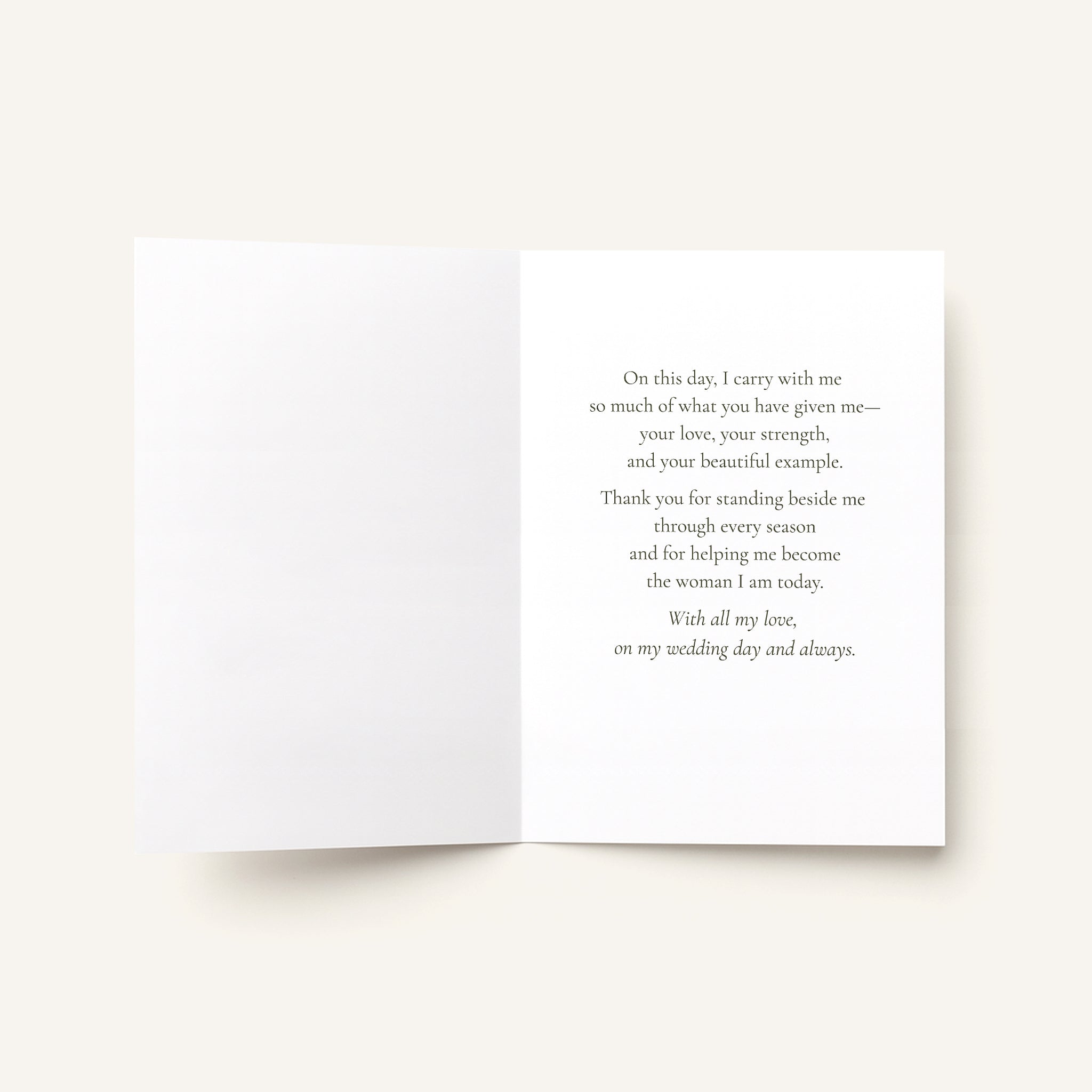 An open white greeting card with a printed message on the right panel, photographed against a warm off-white background.