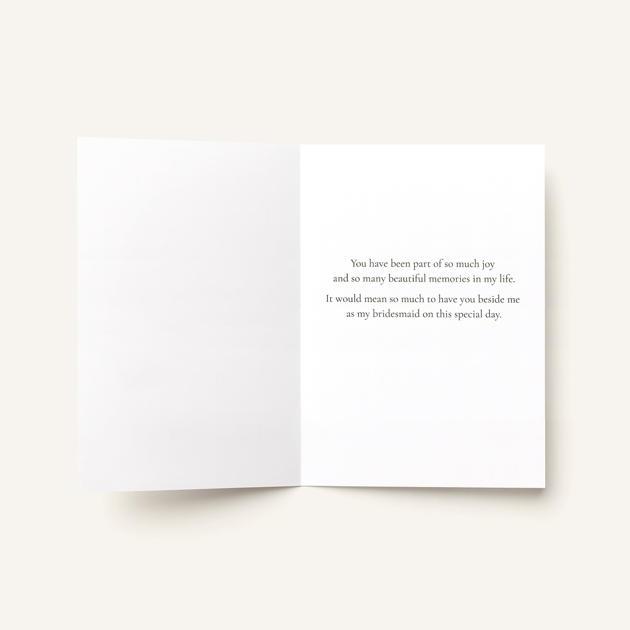 An open white greeting card on a light beige background, with small black text on the right page that reads, 'Wishing you a birthday filled with favorite things, good company, and moments worth remembering.'.