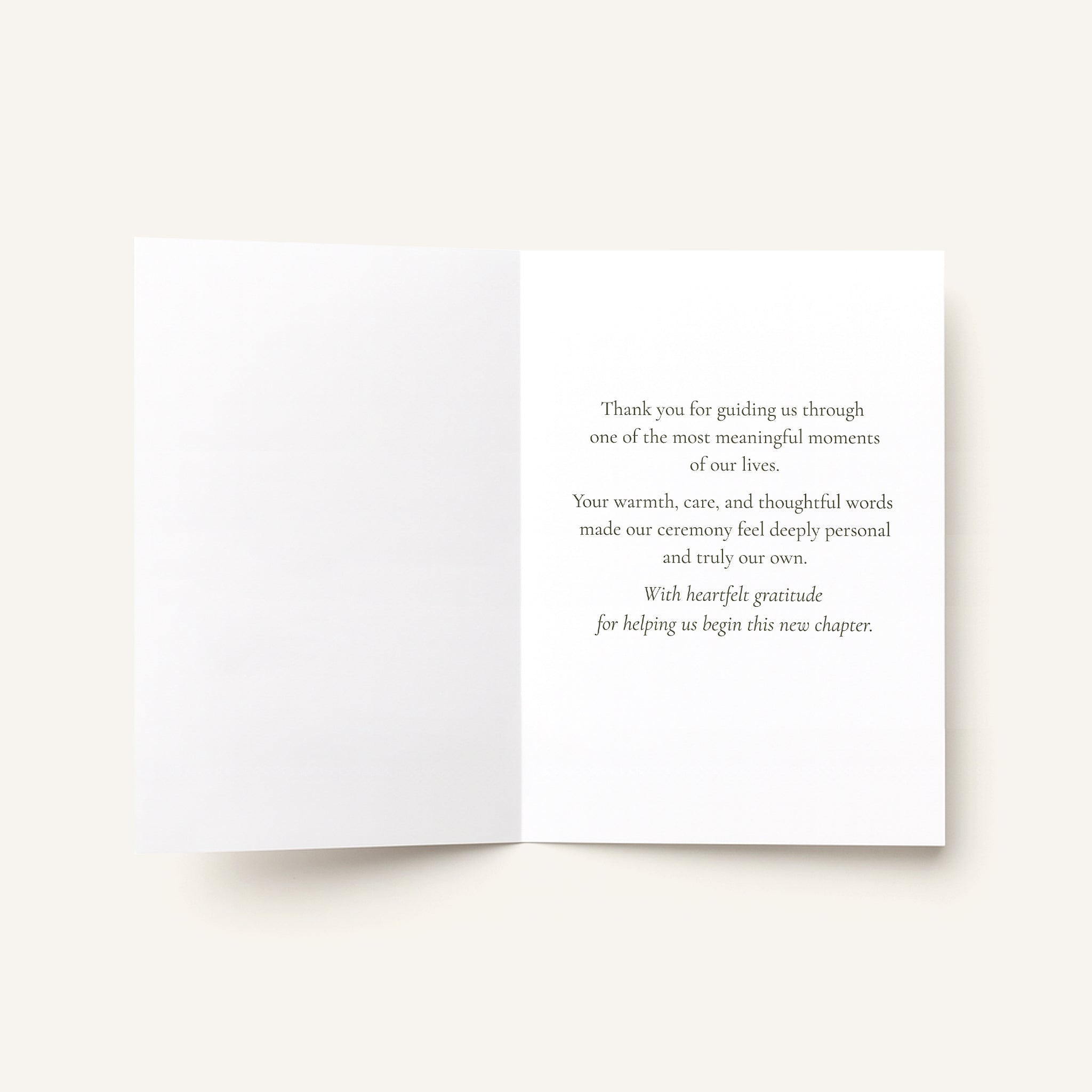 An open white greeting card with printed gray text on the right panel, photographed against a warm off-white background.