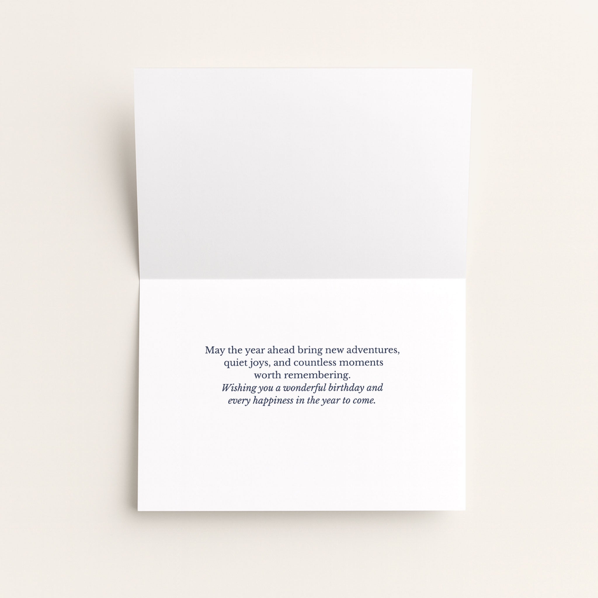 Open birthday card showing the message “May the year ahead bring new adventures, quiet joys, and countless moments worth remembering.”