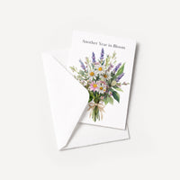 Another Year in Bloom floral birthday card displayed with a coordinating white pointed-flap envelope.