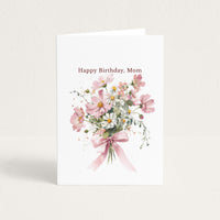 Happy Birthday, Mom card featuring a watercolor bouquet of pink cosmos and white daisies tied with a pink ribbon.