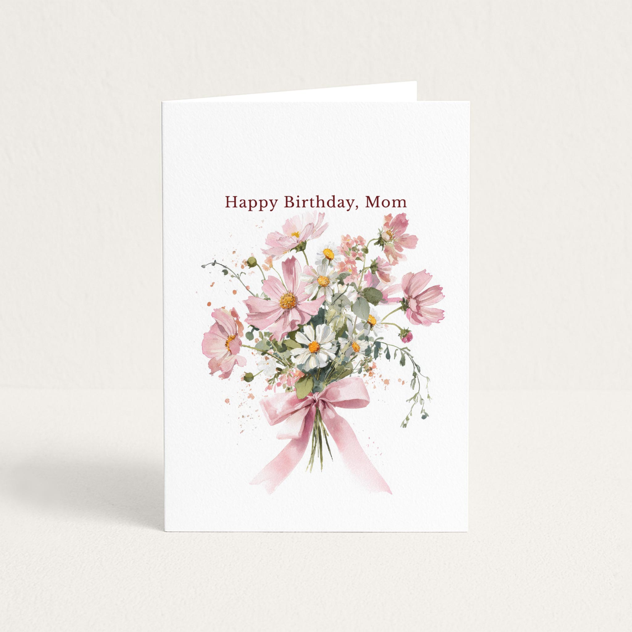 Happy Birthday, Mom card featuring a watercolor bouquet of pink cosmos and white daisies tied with a pink ribbon.