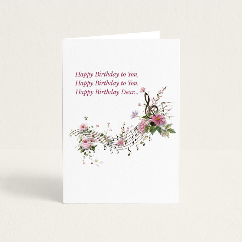 Happy Birthday Dear card featuring floral musical notes, pink blossoms, and the opening lines of the birthday song.