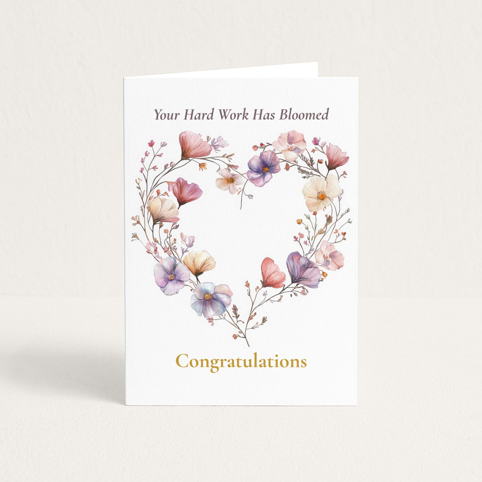Congratulations card featuring a heart-shaped wreath of pink, lavender, and cream watercolor flowers with the message “Your Hard Work Has Bloomed.”