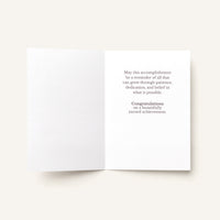 Open congratulations card showing the message “Congratulations on a beautifully earned achievement.”