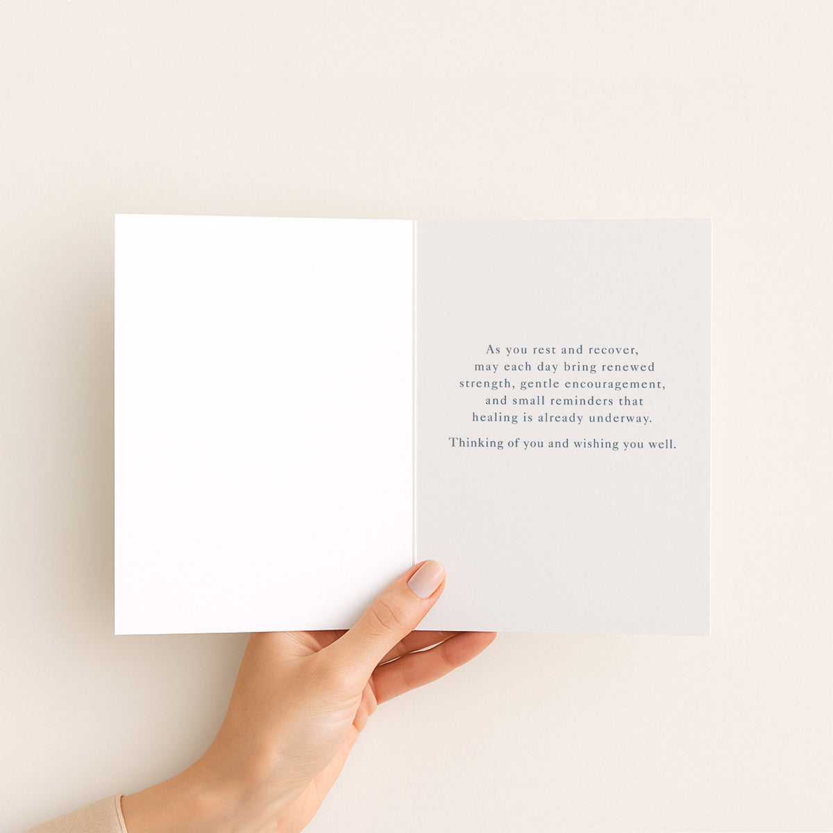 Open get-well card held in hand, showing a message of rest, renewed strength, gentle encouragement, and healing.