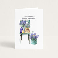Friendship card featuring watercolor lavender arranged on a vintage green chair and in a market pail, with the message “When I see the beauty of lavender in Provence, I think of you.”