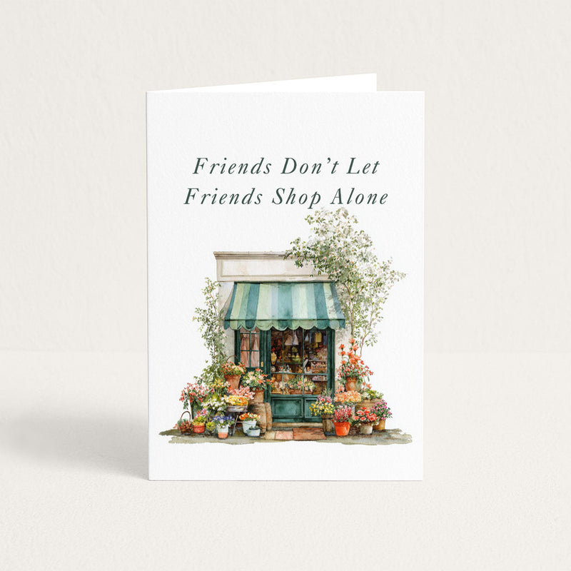 Friends Don’t Let Friends Shop Alone friendship card featuring a watercolor flower shop with a green striped awning.