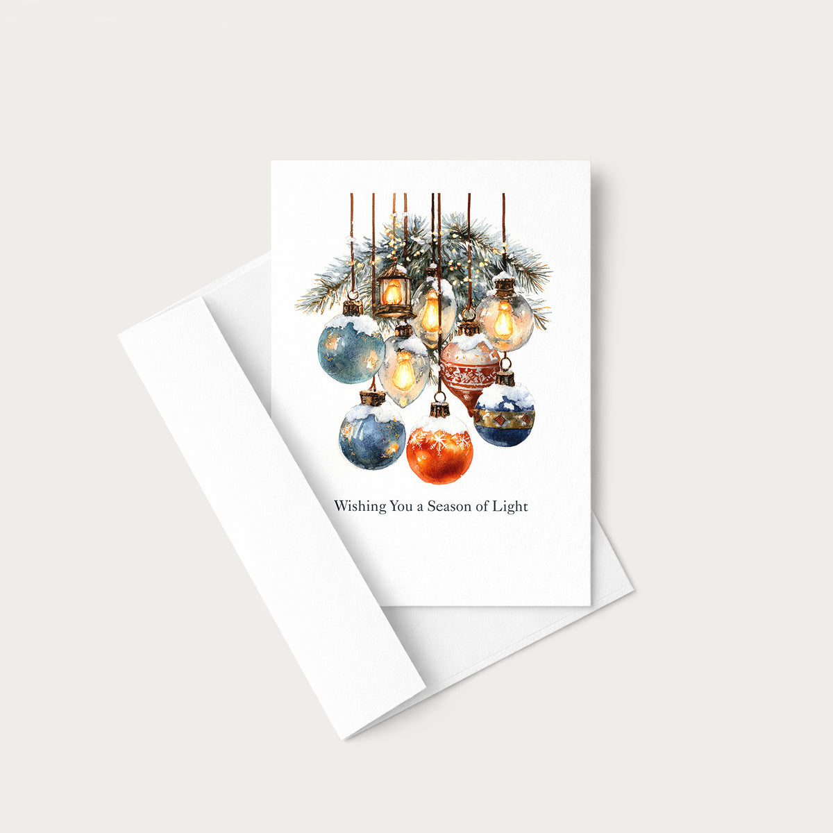 Wishing You a Season of Light holiday card displayed with a coordinating white pointed-flap envelope.