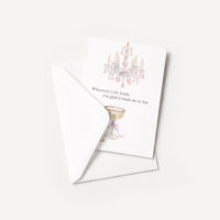Romantic chandelier and champagne coupe card displayed with a coordinating white pointed-flap envelope.