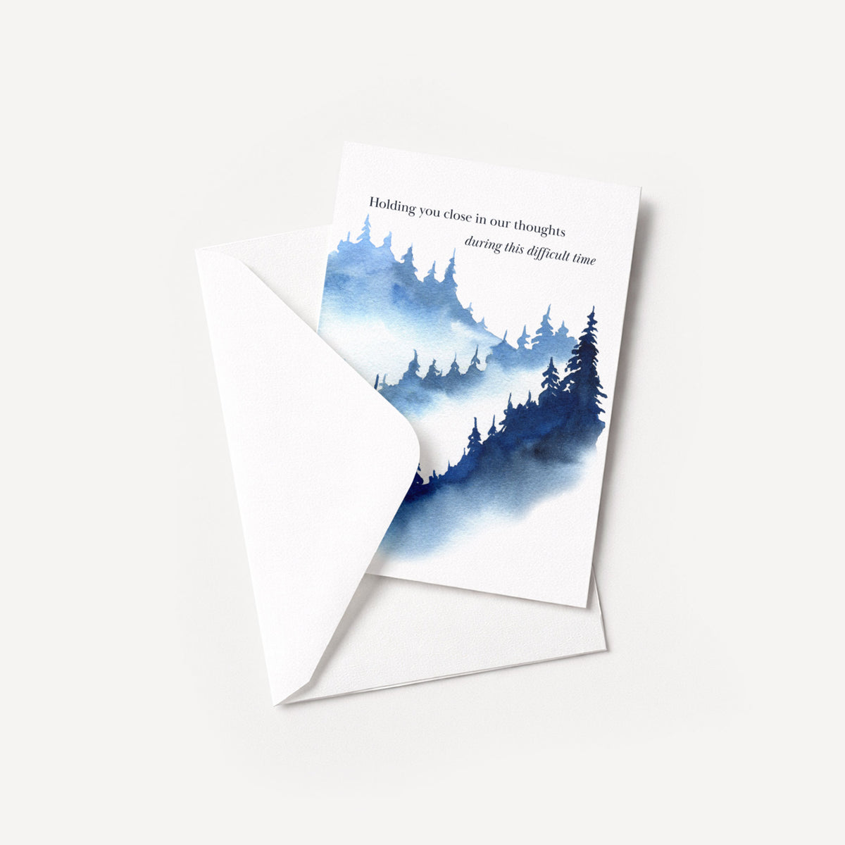 Blue forest sympathy card displayed with a coordinating white pointed-flap envelope.