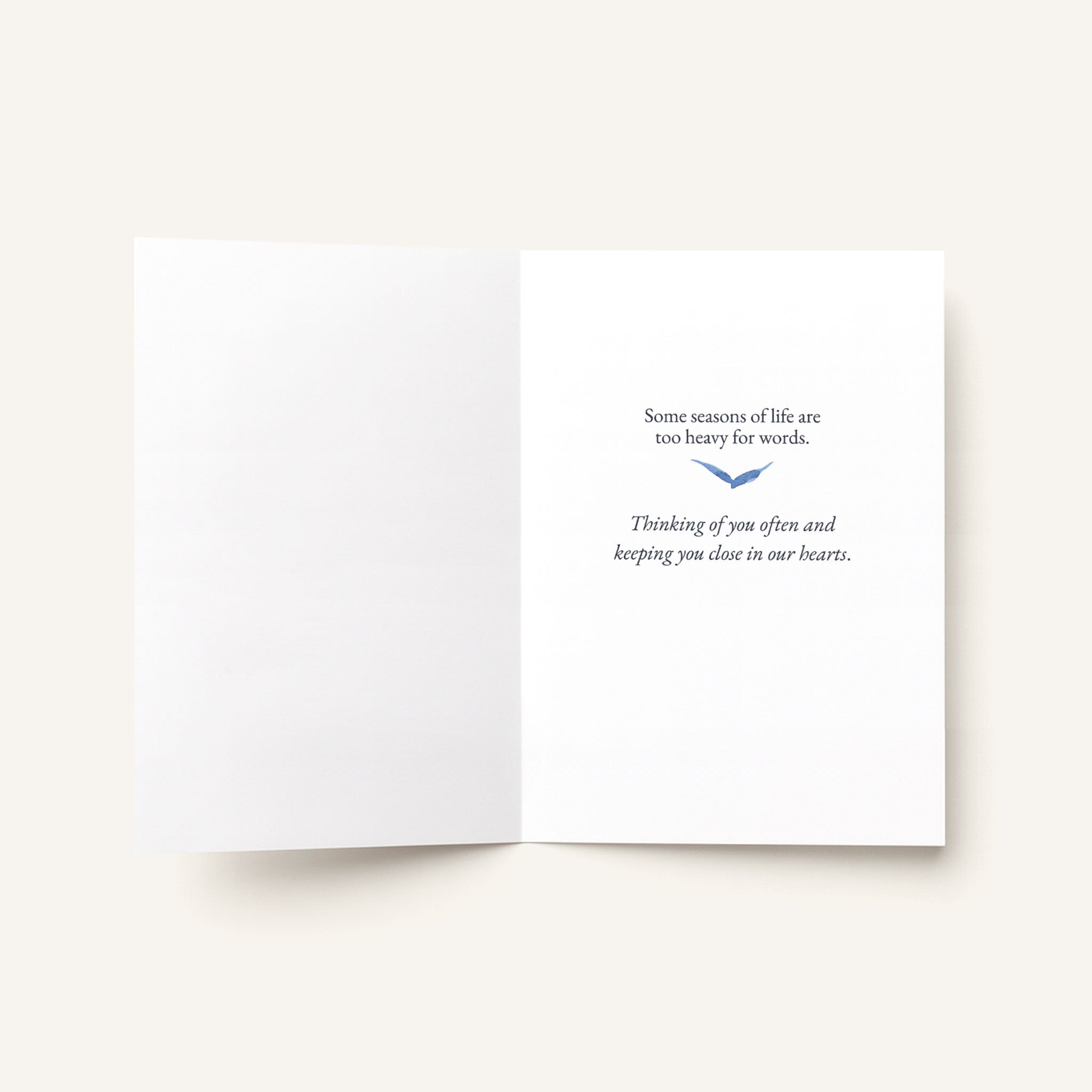 Open sympathy card showing a blue bird and the message “Some seasons of life are impossibly heavy. Thinking of you often and holding you close in our hearts.”
