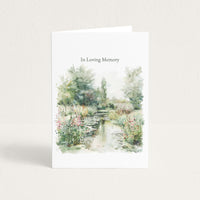 Sympathy card featuring a soft watercolor garden pond with flowers and trees beneath the words “In Loving Memory.”