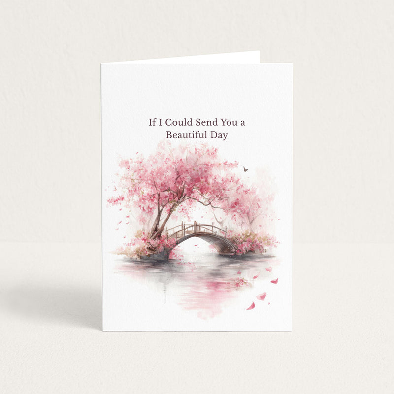 Thinking-of-you greeting card featuring a pink watercolor cherry blossom tree and arched garden bridge with the message “If I Could Send You a Beautiful Day.”