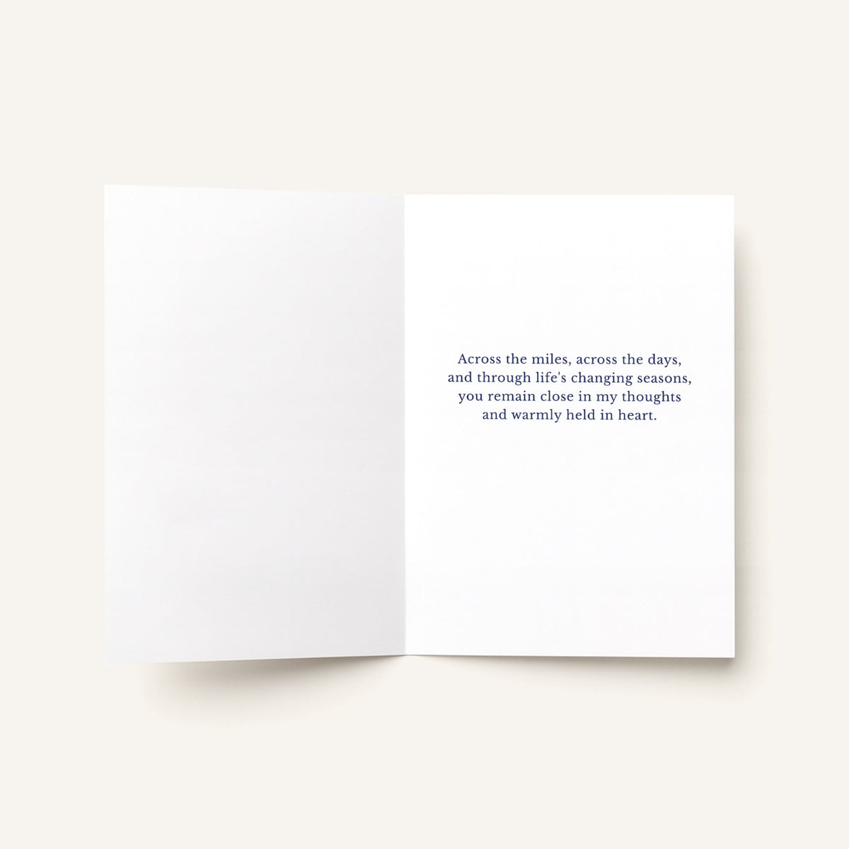 Open thinking-of-you greeting card showing a printed message about remaining close across the miles and through life’s changing seasons.