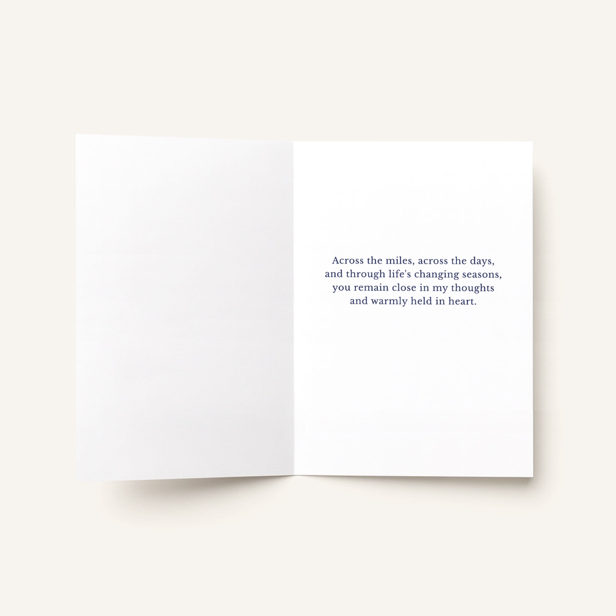 Open thinking-of-you greeting card showing a printed message about remaining close across the miles and through life’s changing seasons.