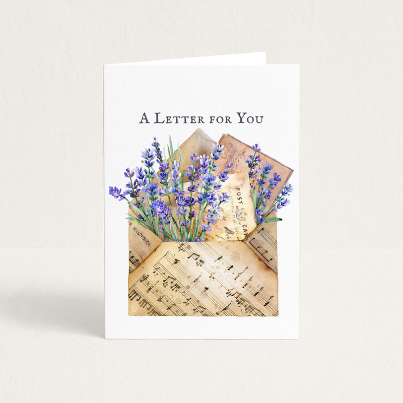 A Letter for You thinking-of-you card featuring lavender flowers, vintage postcards, and a sheet-music envelope.