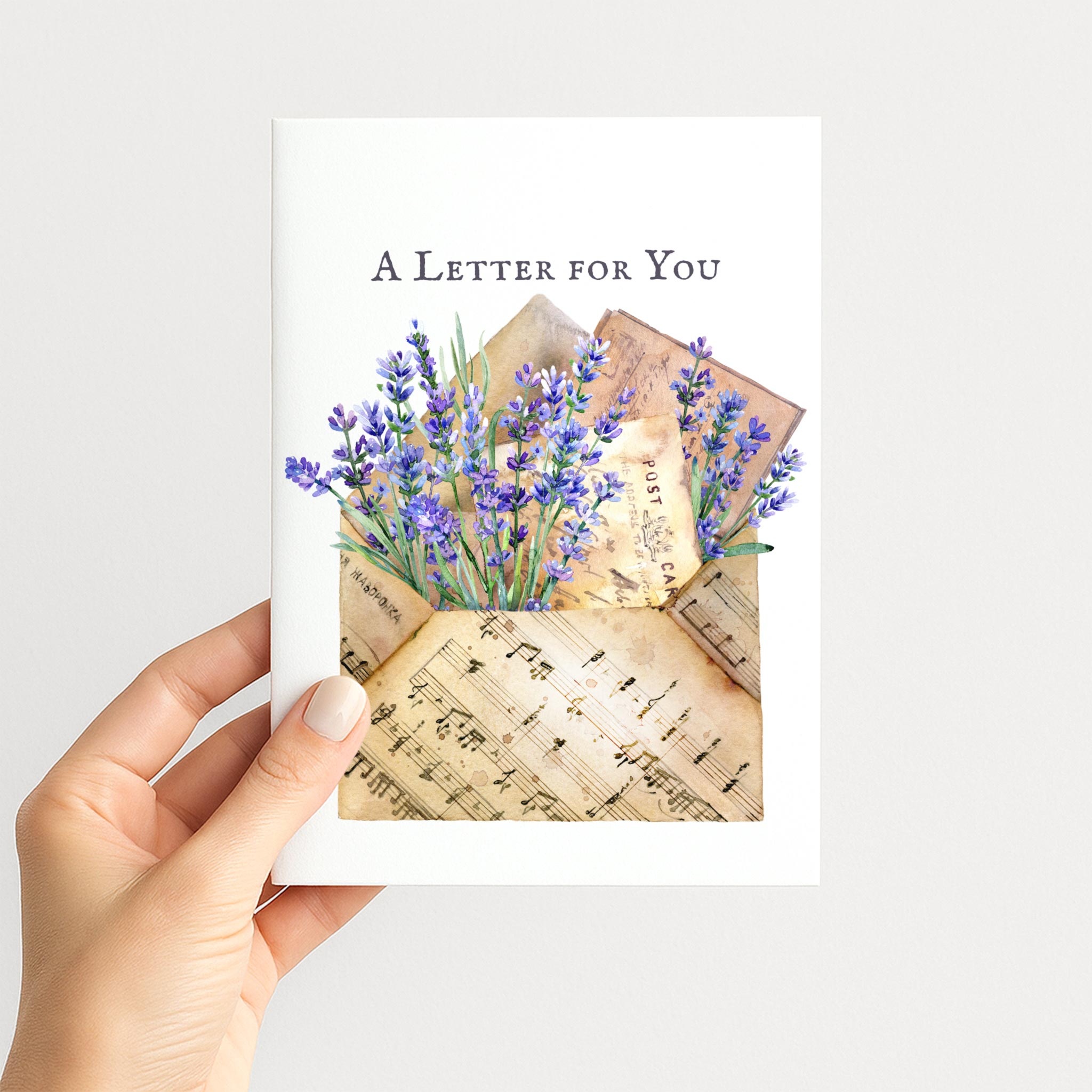 Hand holding A Letter for You card featuring lavender, vintage correspondence, and musical notation.
