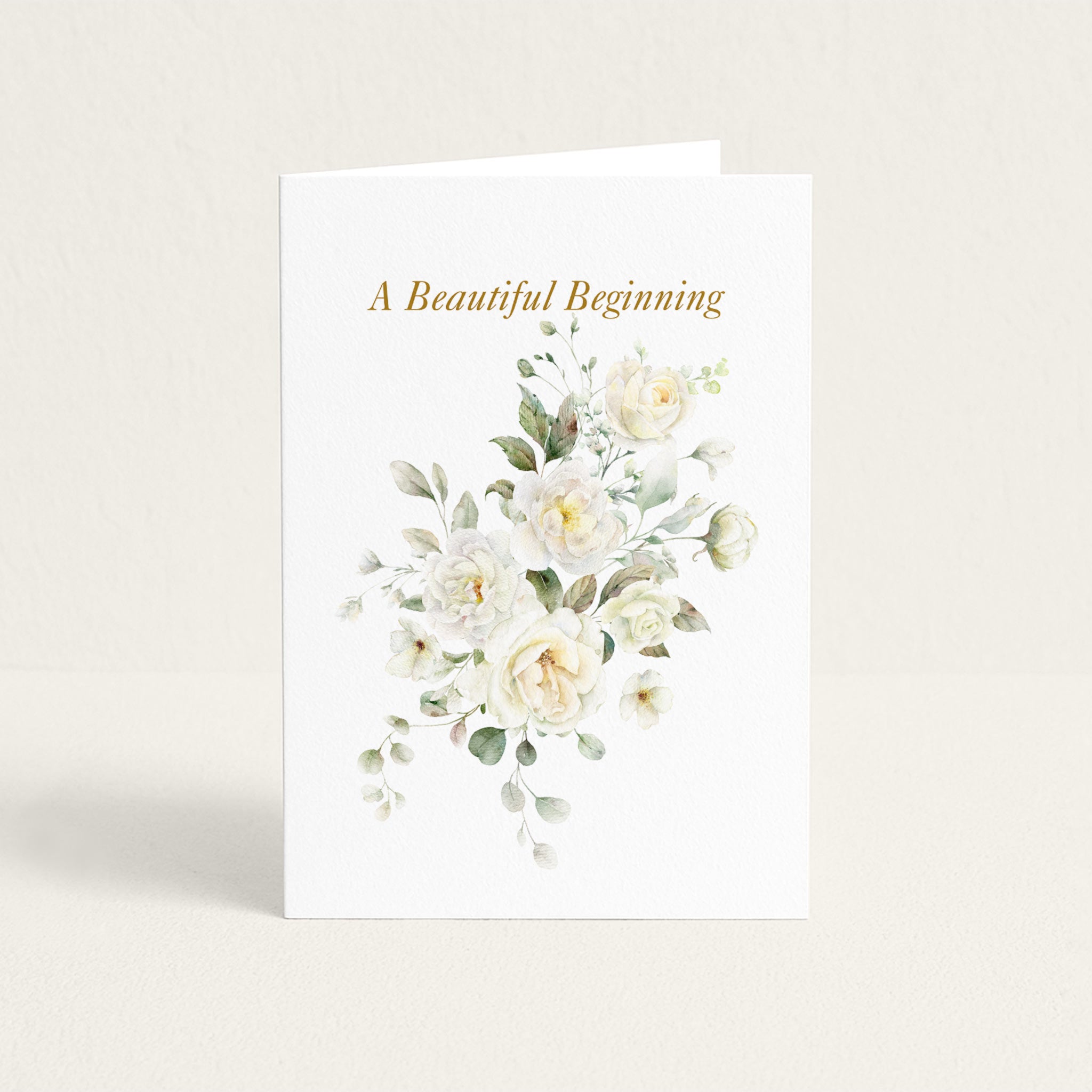 A Beautiful Beginning wedding card featuring soft white watercolor roses and greenery on textured white paper.