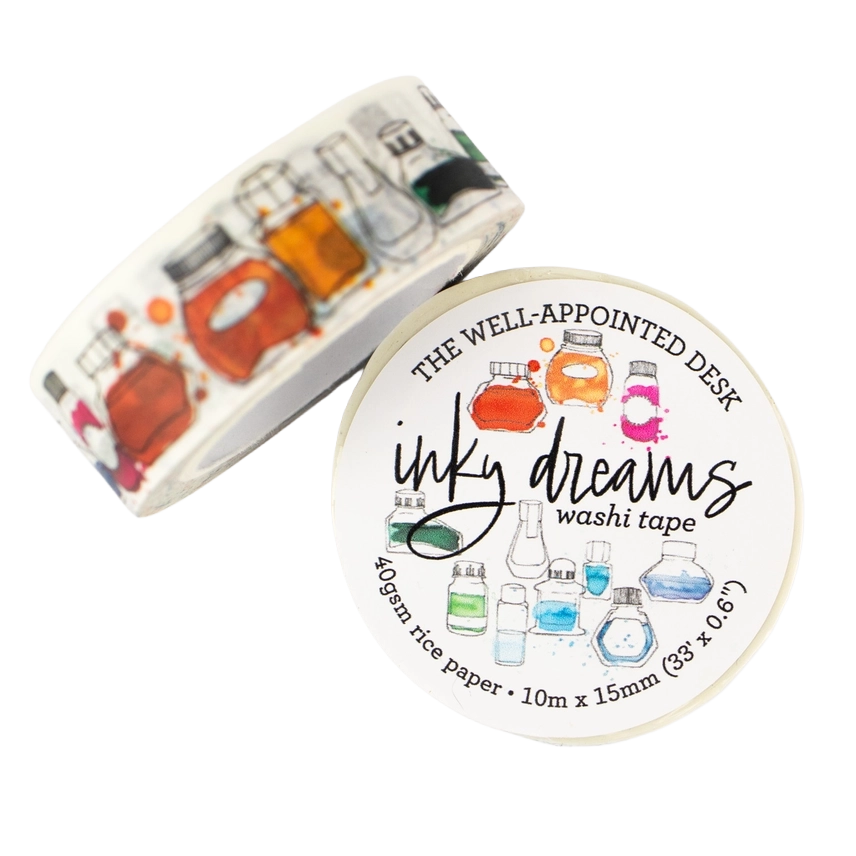 A roll of washi tape and its circular label, both featuring a white background with colorful illustrations of glass laboratory bottles and beakers. The label reads 'THE WELL-APPOINTED DESK', 'inky dreams', and 'washi tape'.