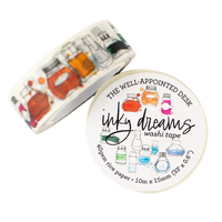 A roll of washi tape and its circular label, both featuring a white background with colorful illustrations of glass laboratory bottles and beakers. The label reads 'THE WELL-APPOINTED DESK', 'inky dreams', and 'washi tape'.
