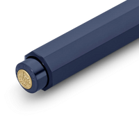 Close-up of a dark navy blue cylindrical product, likely a pen or tool, showing a gold circular emblem on the cap against a clean white background.