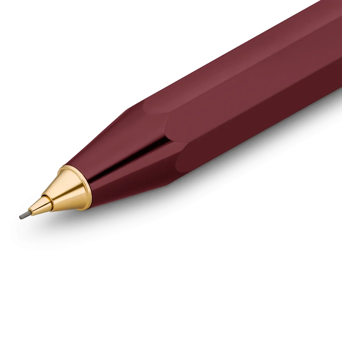 A close-up of a faceted metallic pen tip in deep burgundy with a polished gold conical accent and fine gray tip, shown on a clean white background.