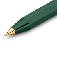A close-up of a faceted dark green pen tip with a polished gold metal point and a silver writing nib, shown on a clean white background.