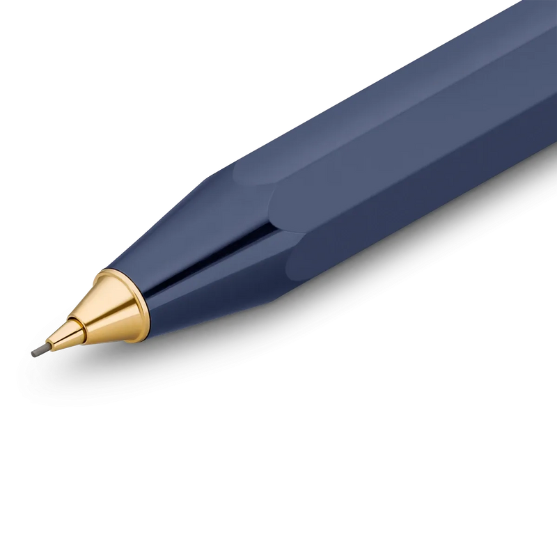 A close-up of a faceted navy blue pen tip with a polished gold metal cone and a fine silver writing point, shown on a clean white background.