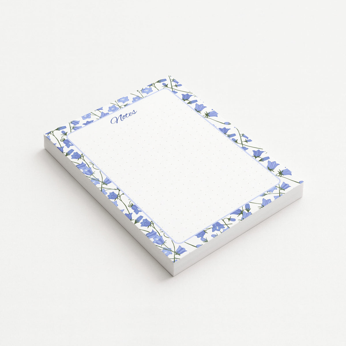 Bluebell Garden memo pad shown at an angle with a blue bellflower border, script Notes heading, and subtly dotted writing area.