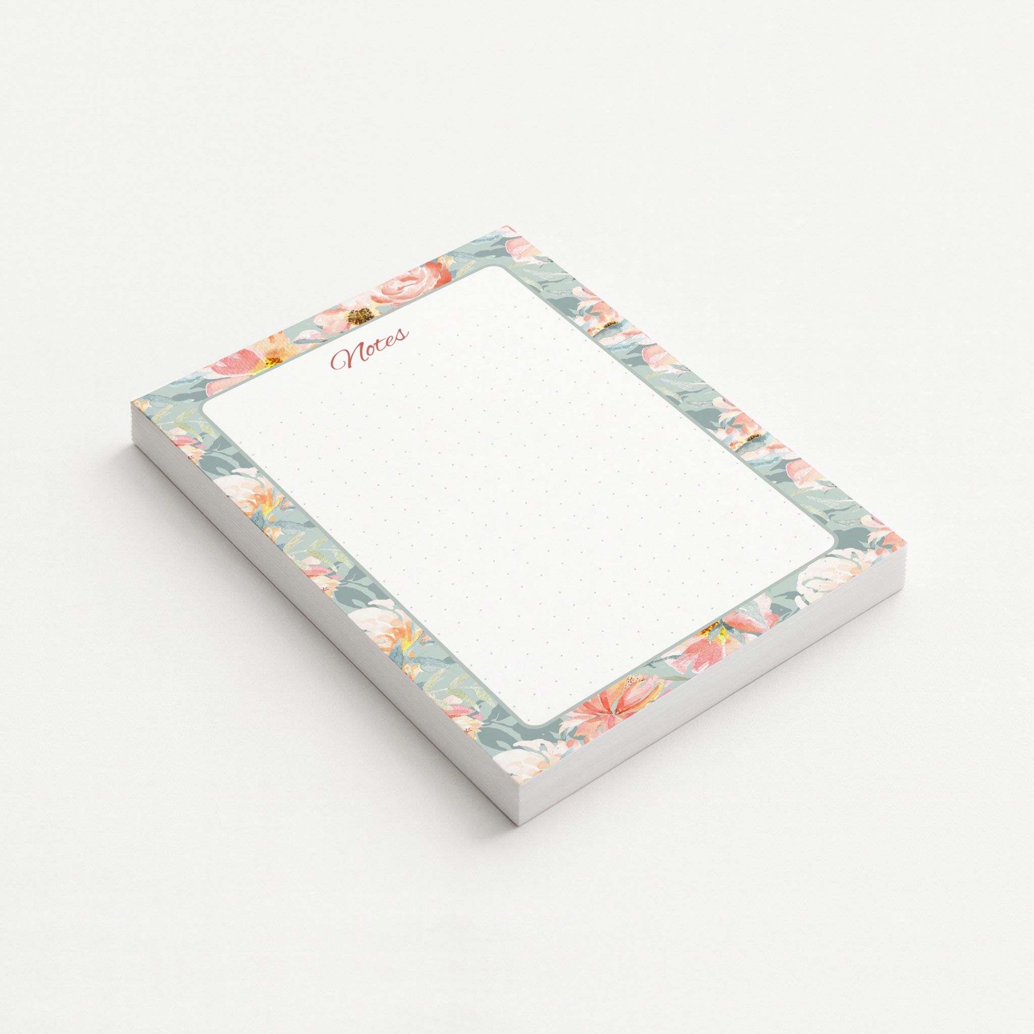 Blush Garden memo pad shown at an angle with a watercolor border of coral, blush, and ivory flowers on a misty sage background.