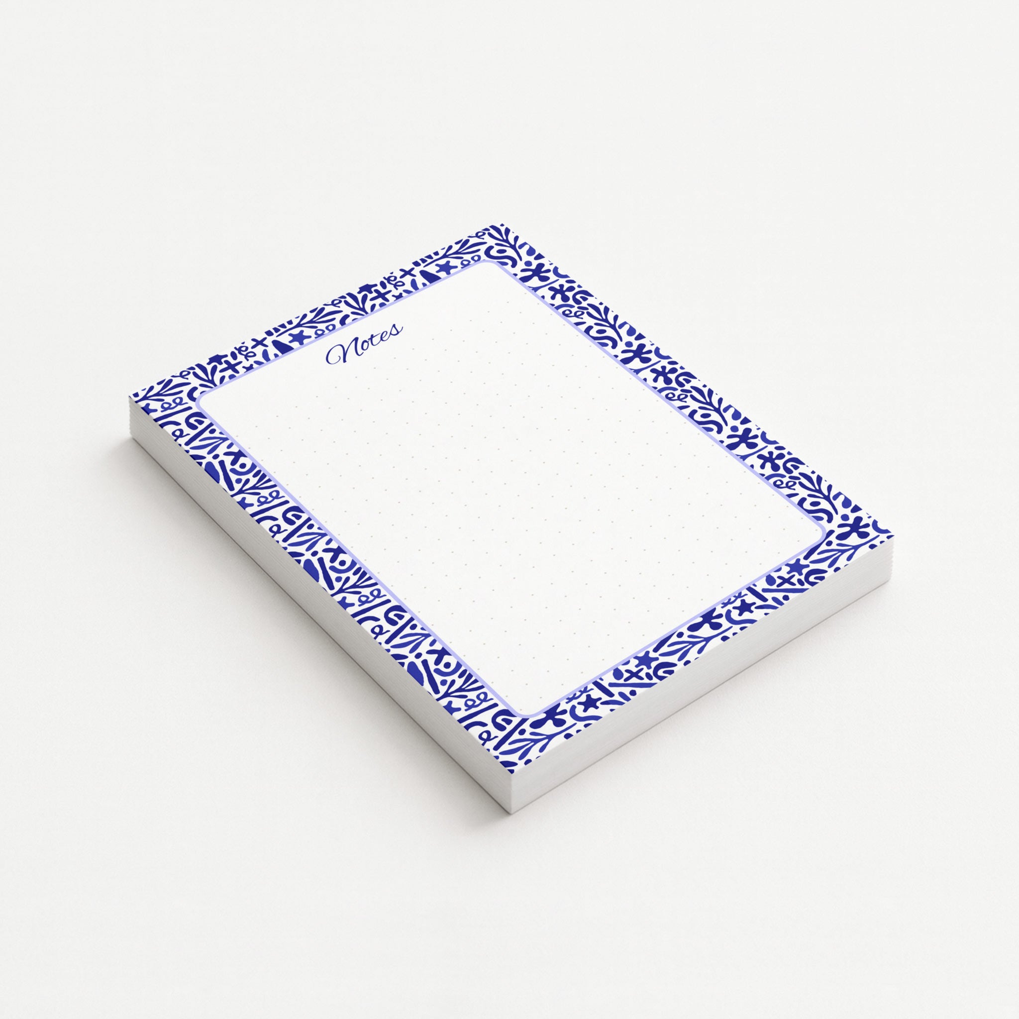 Indigo Botanica memo pad shown at an angle with a deep blue botanical border, lavender rounded frame, and subtly dotted writing area.
