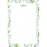 Front view of the Lily of the Valley memo pad with pale blue blossoms and green foliage surrounding a spacious dotted writing panel.