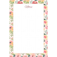 Front view of the Painter’s Garden memo pad with blush, coral, red, and yellow flowers framing a spacious, subtly dotted writing panel.