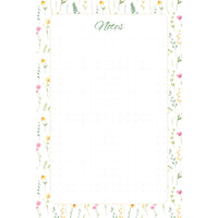 Front view of the Wildflower Meadow memo pad with slender pink and yellow flowers and green foliage framing a spacious, subtly dotted writing panel.