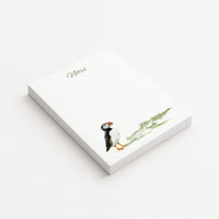 White 4.25" × 5.5" memo pad with olive “Notes” lettering and a watercolor Atlantic puffin beside soft green coastal grasses.