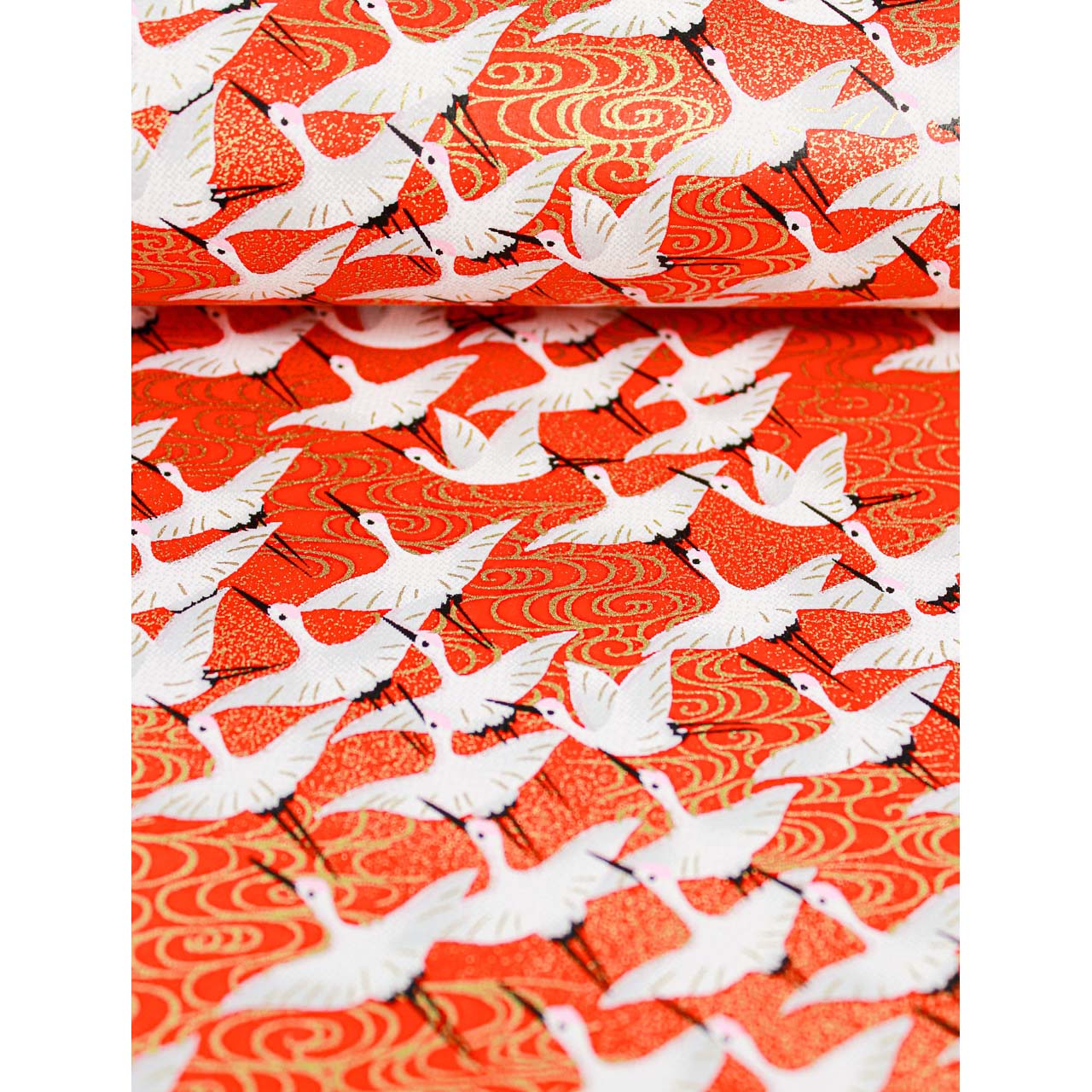 Close-up of hand silk-screen printed Chiyogami paper showing white cranes, black details, and warm gold wave motifs on red.