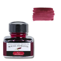 A bottle of Herbin Rouge Amarante writing ink with a black cap and a white label, shown next to a pinkish-red ink swatch on a white background.